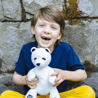 Little Boy Holding Stuffed Polar Bear Made from Recycled Plastic