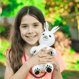 Little Girl Holding Arctic Hare Stuffed Animal made from Recycled Plastic